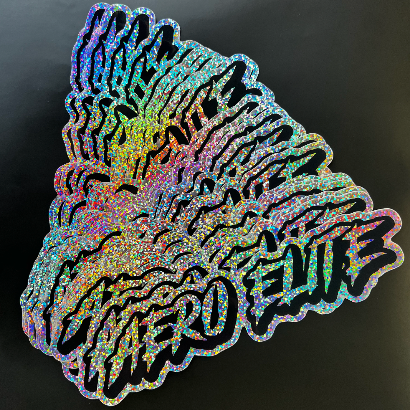 Selection of neochrome glitter sparkle stickers on a neutral background.