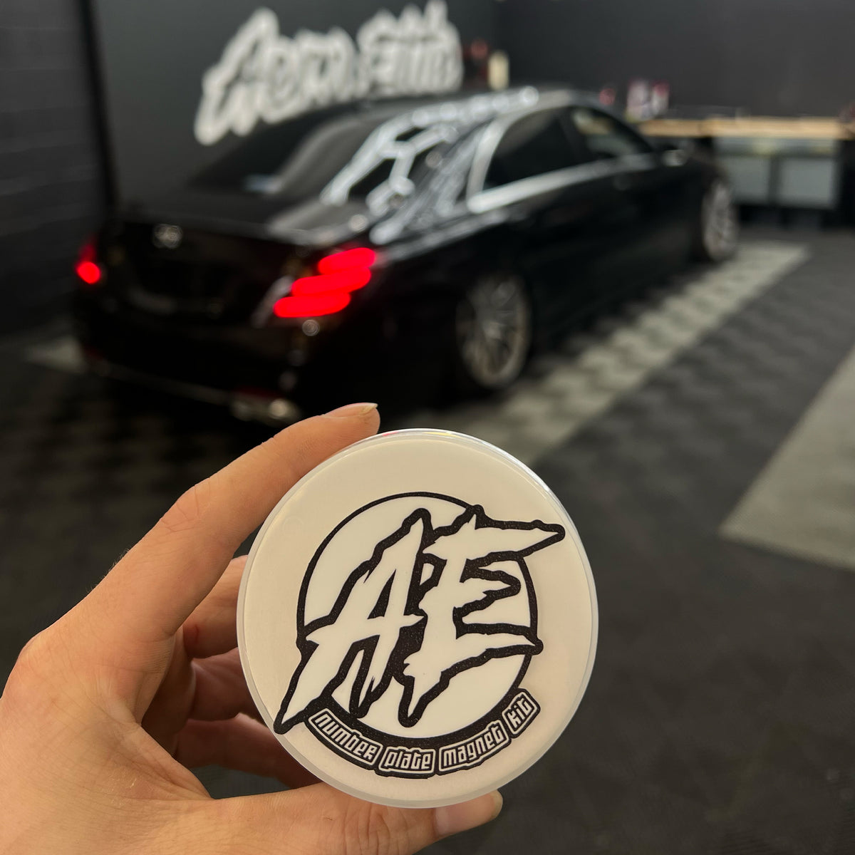 Aero Elite Number Plate Magnet Kit being held infront of Mercedes W222 S Class inside WImborne Workshop.