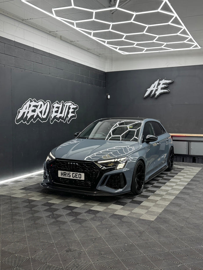 Audi RS3 8Y front three-quarter hero shot with new wheels, splitter and spoiler