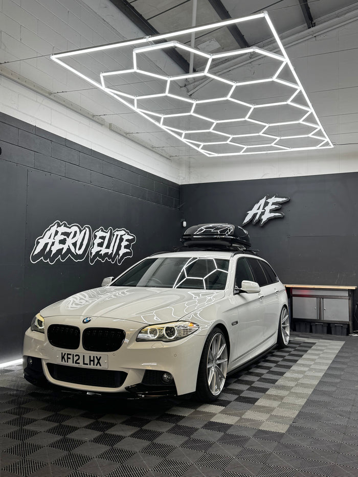BMW 5 Series F11 Touring front three-quarter hero shot after gloss black grille, splitter, side skirts, lowered suspension and new wheels