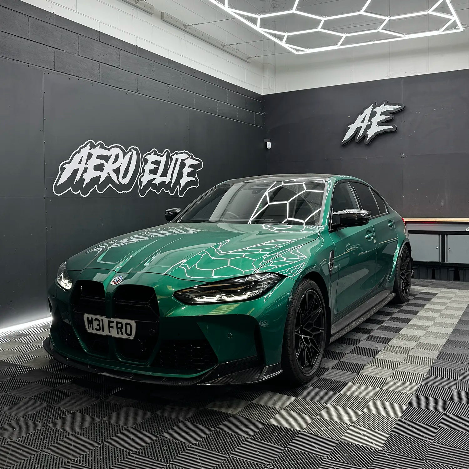 Isle of Man Green G80 M3 with a full carbon kit in a brightly lit fitting studio.