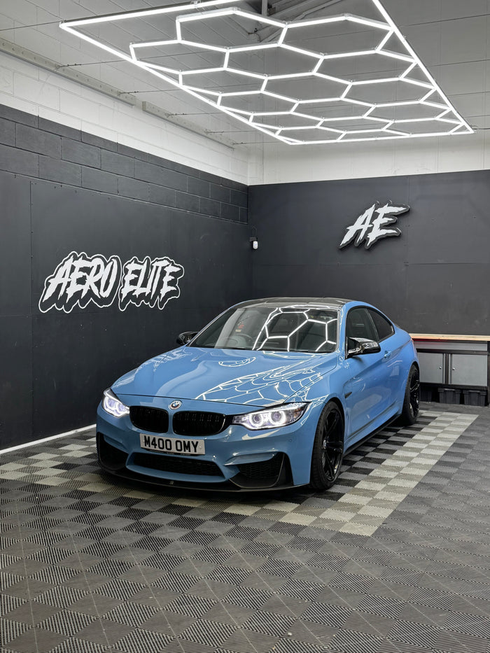 BMW M4 F82 after carbon side skirt fitment and wheel refurbishment — front three-quarter view