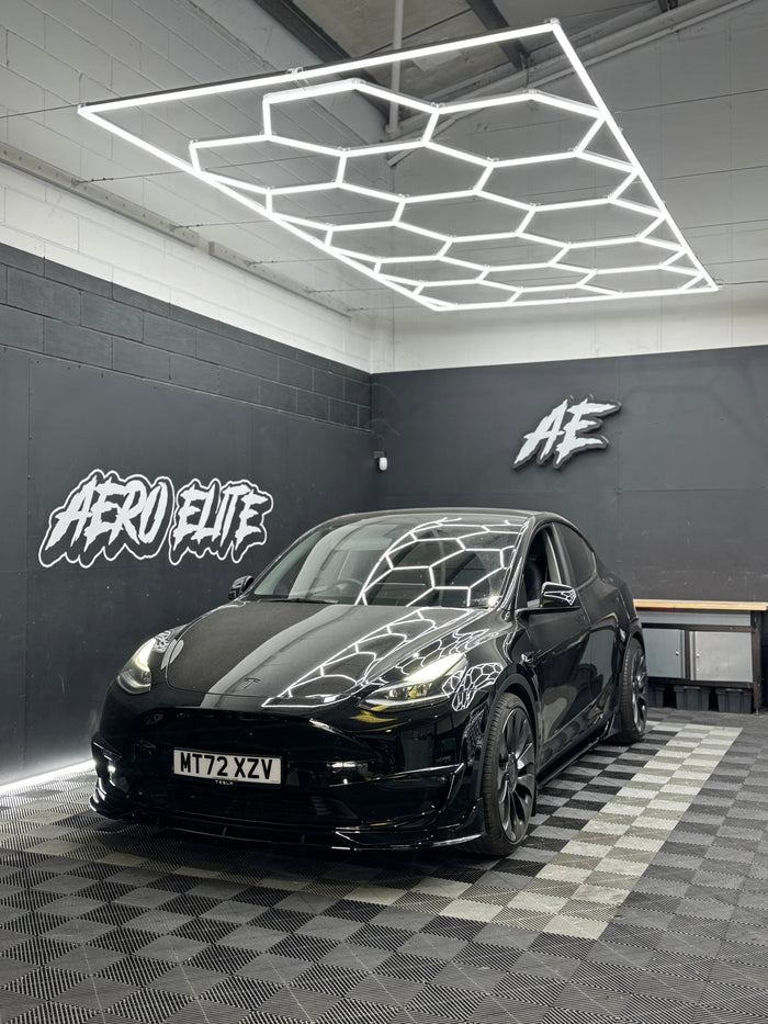 Tesla Model Y with full aero kit by Aero Elite — front splitter, side skirts and lowered suspension, front three-quarter view