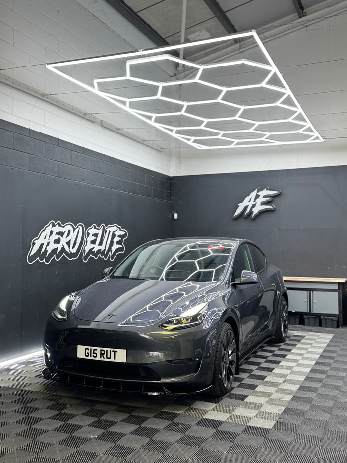 Grey Tesla Model Y with front splitter and side skirts by Aero Elite, front three-quarter view
