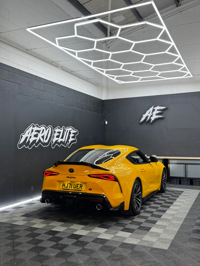 Yellow Toyota Supra (MK5) with carbon fibre spoiler by Aero Elite, rear three-quarter view